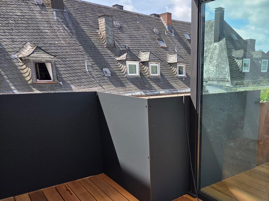 Glass balustrade and parapet against the neighbouring roofs