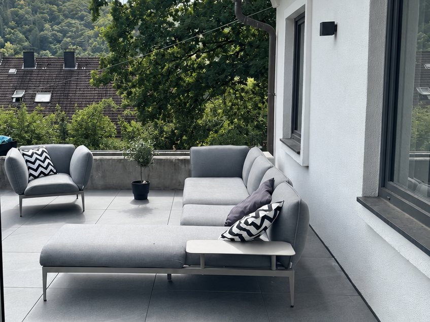 Terrace with large-format porcelain stoneware and lounge furniture, looking out onto greenery