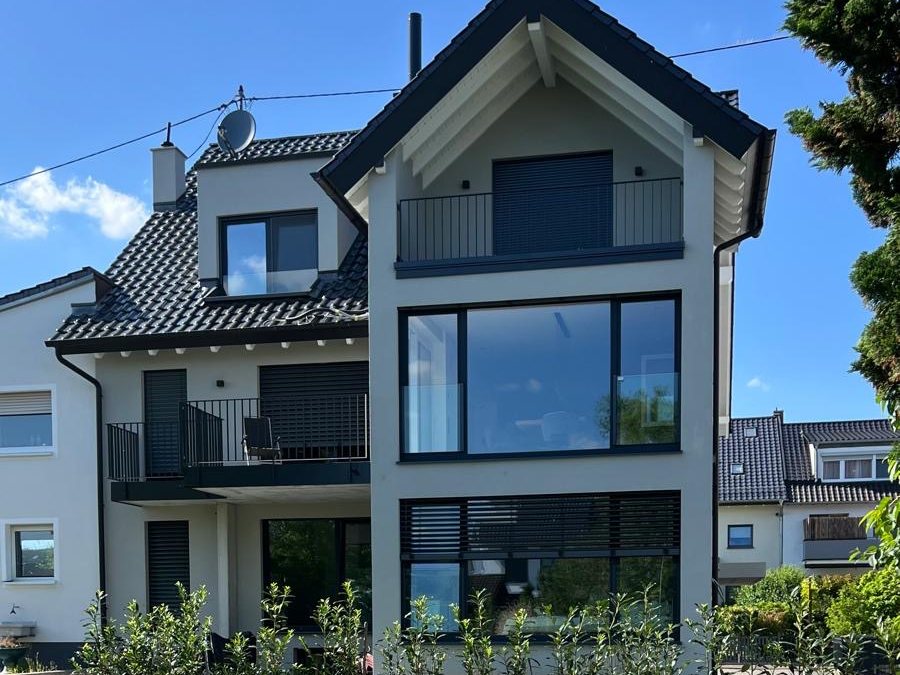 House with large window fronts, balconies and a newly laid-out garden